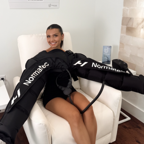 Female receives compression massage for her arms after a barre workout