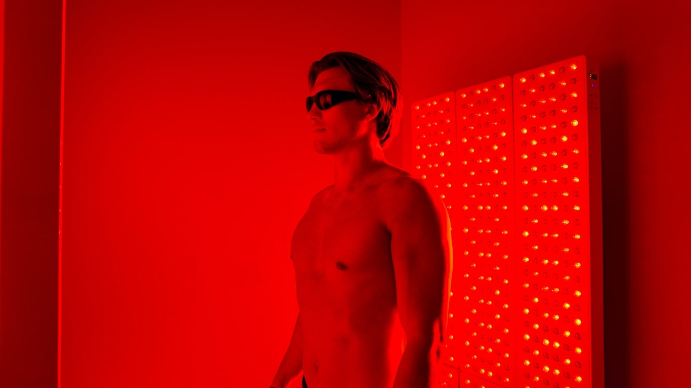 Man using a red light therapy panel at Degree Wellness